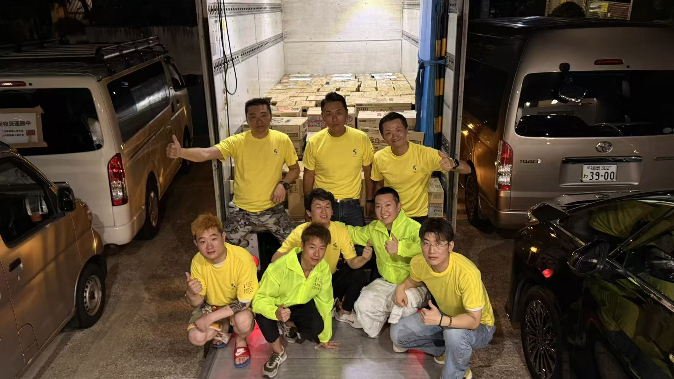 支援物資を積んだ車両の前での集合写真。
